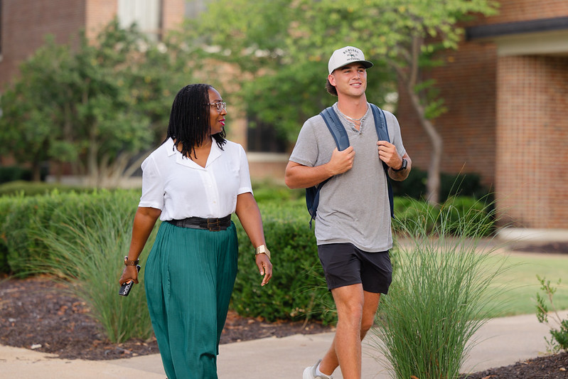Photo of two people walking on campus.